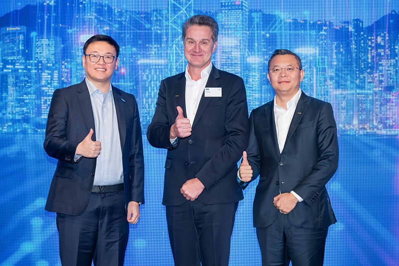 SVP-Joe-CEO-Philippe-and-SVP-Eric-stand-on-the-stage-for-the-group-photo